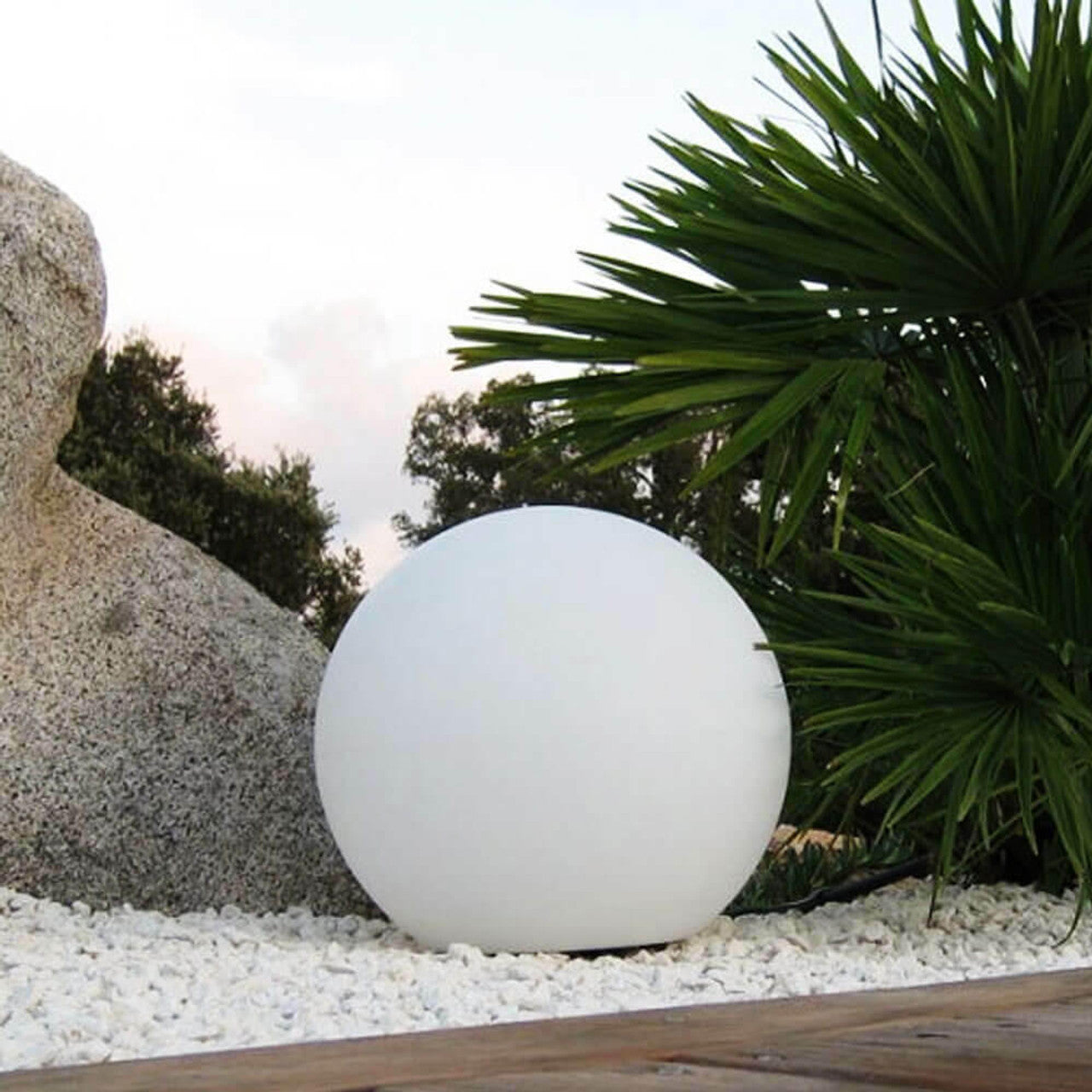 Close-up of a Waterproof Outdoor LED Ball Lights Décor 50cm, floating on a rock, perfect for creating ambient lighting in outdoor spaces like pools and gardens.