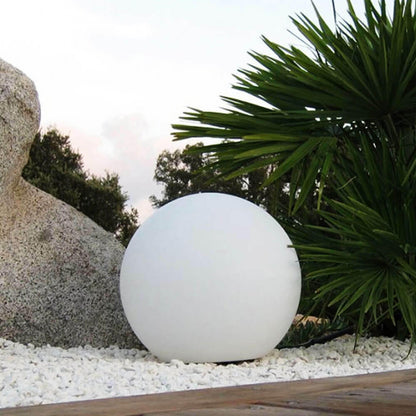 Close-up of a Waterproof Outdoor LED Ball Lights Décor 50cm, floating on a rock, perfect for creating ambient lighting in outdoor spaces like pools and gardens.