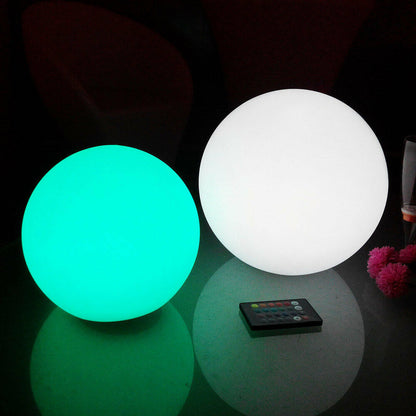 Close-up of two glowing Luxo Outdoor LED Ball lights, showcasing their sleek round design with a remote control, highlighting the Waterproof Outdoor LED Ball Lights Décor 50cm's floatable feature for magical outdoor settings.