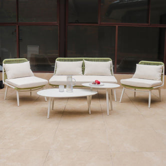 Lowanna 4pc Aluminium Rope Wicker Outdoor Lounge Set Mint Green features a two-seater sofa, armless chairs, and two coffee tables on a patio, showcasing modern design and comfort.