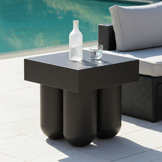Square black outdoor side table with a thick tabletop and four chunky, rounded cylindrical legs.