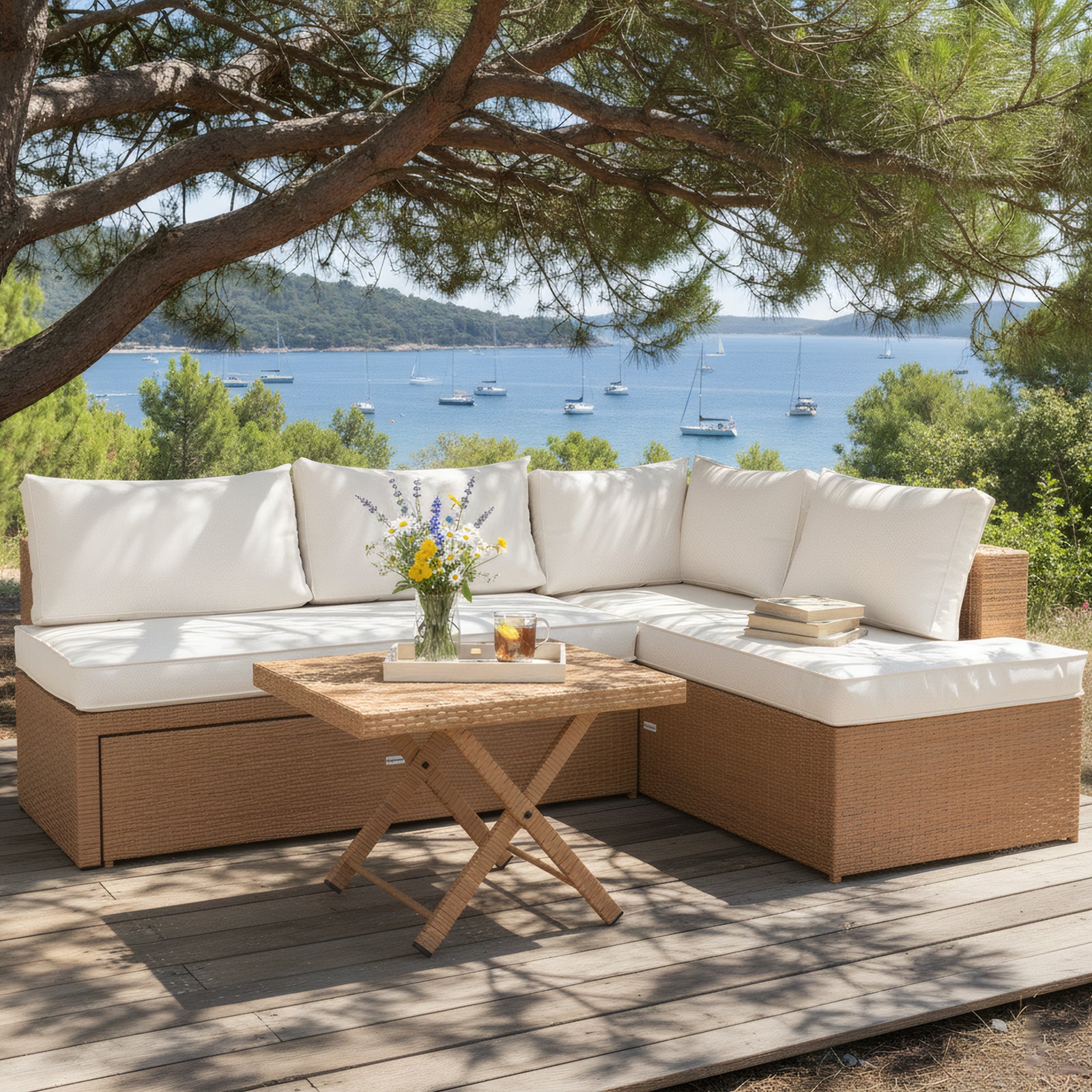 L-shaped outdoor wicker lounge set with white cushions and a square wicker coffee table on a wooden deck overlooking the ocean.