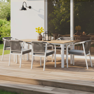 7-piece outdoor dining set with a timber-top table and six white aluminum chairs featuring grey rope-woven backs and charcoal cushions.