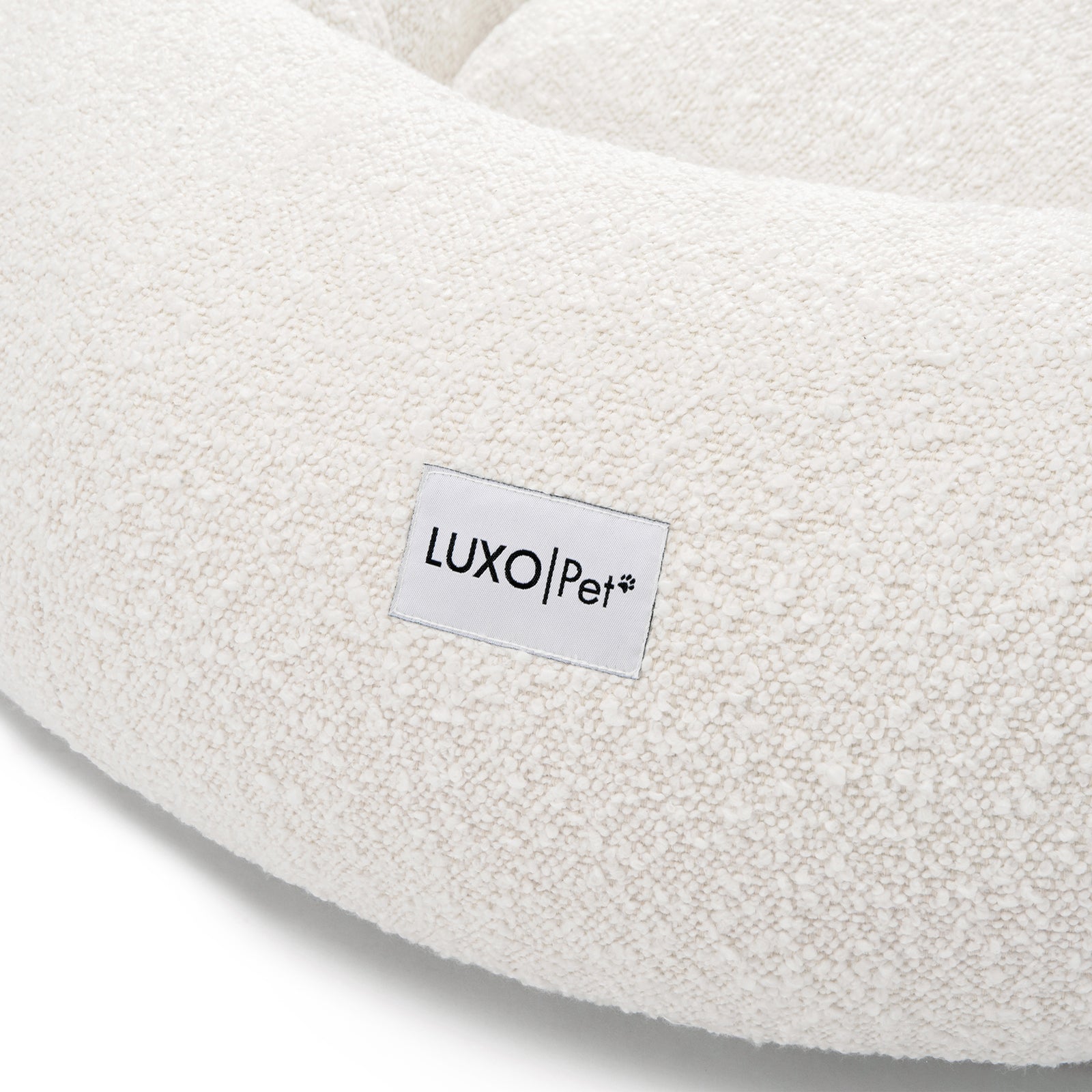 Kyra Medium Boucle Pet Bed – Light Beige Comfort, featuring plush boucle fabric and a supportive, sculpted design with a visible white label, ideal for modern décor and pet relaxation.
