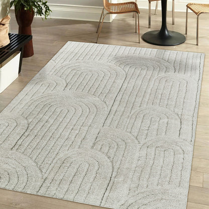 Aetherine Soft Contemporary Rug 120x180cm displayed in a cozy setting, showcasing its 12mm soft pile and modern print, complemented by a hand and furniture elements, emphasizing its comfort and style.