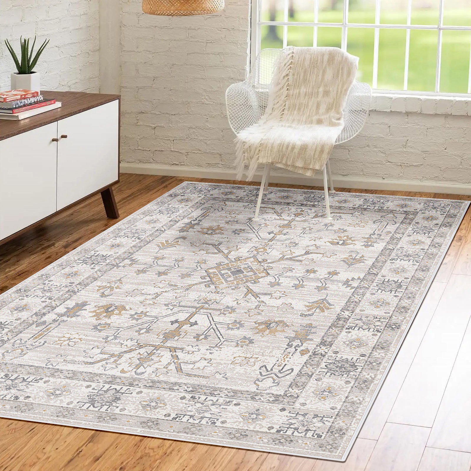 Bortan Persian Indoor Rug 160x230cm on hardwood floor, featuring muted neutrals with a distressed medallion pattern, enhancing a minimalist living space with a mid-century sideboard and white mesh chair.