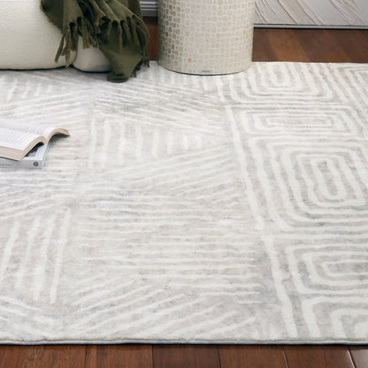 Duved 200x300cm Large Contemporary Indoor Floor Rug with subtle geometric patterns in off-white and pale gray, displayed on dark hardwood floor, enhancing a cozy living-room setting with a cream sofa and side table.