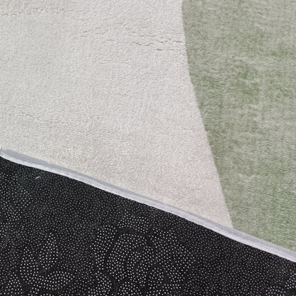 Gonas 200x300cm Large Abstract Indoor Floor Rug featuring a light beige background with a muted green shape, and a black, dot-patterned non-slip backing corner flipped over.