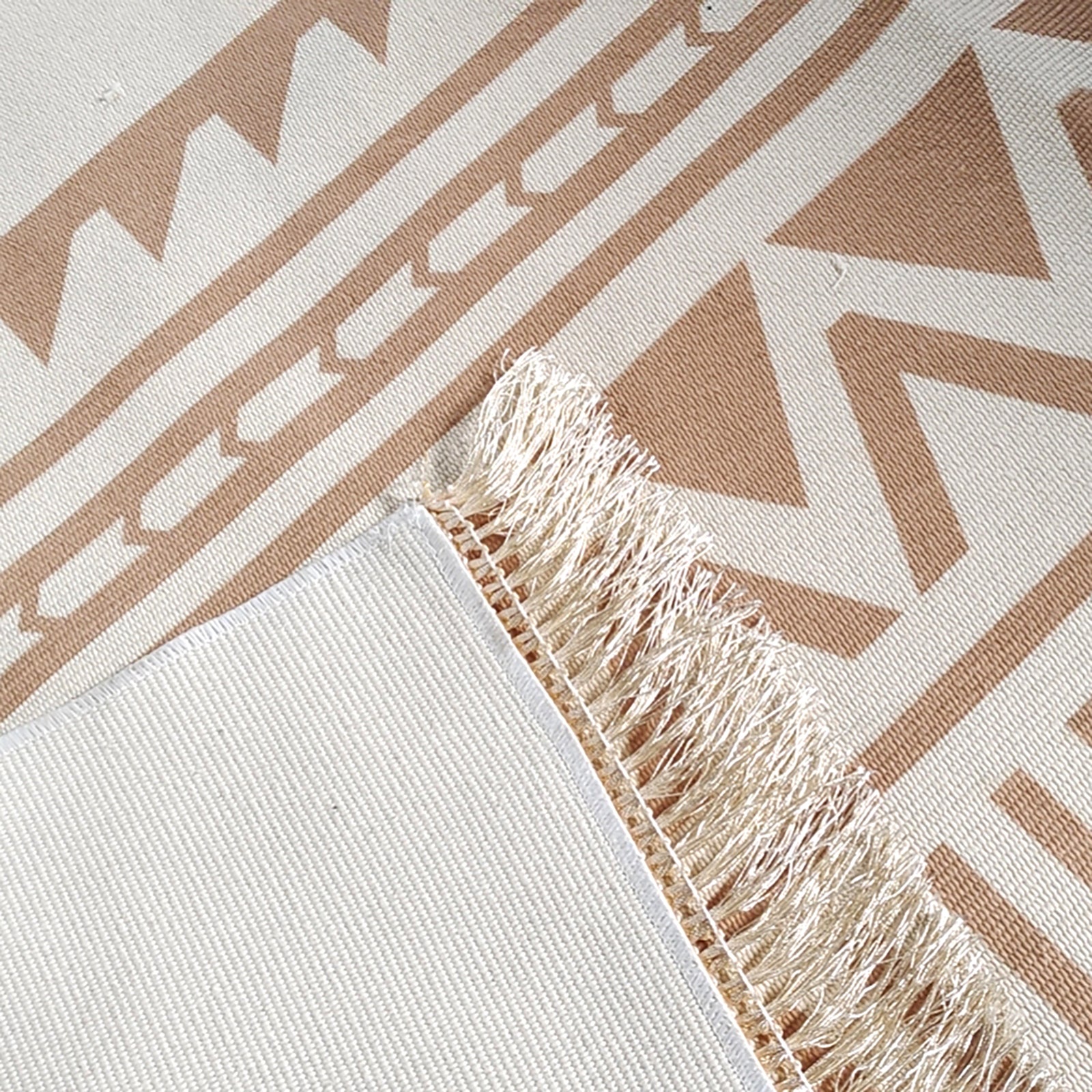 Kaley 160x230cm Woven Cotton Blend Tasseled Indoor Rug features cream and tan geometric patterns with a stitched edge and short fringes, showcasing its sophisticated and modern design.