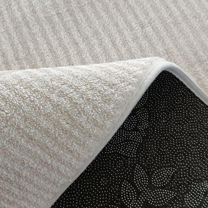 Krokom 160x230cm Modern Abstract Indoor Floor Rug featuring a soft, towel-like pile and dark non-slip backing, partially flipped to reveal its underside, showcasing its durable and practical design.