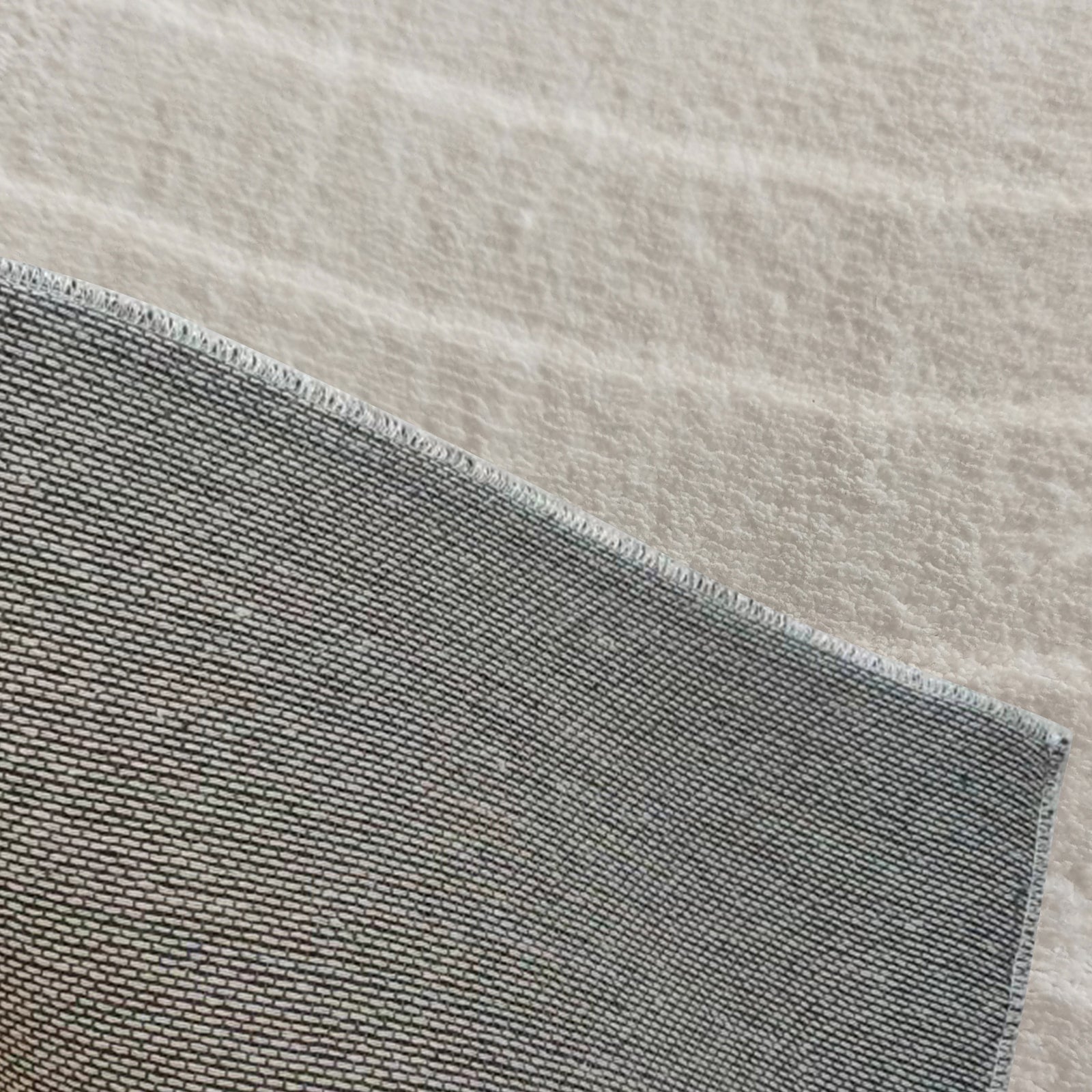 Close-up of Lita 160x230cm Polyester Tufted Modern Abstract Rug, showcasing its plush tufted texture and anti-slip cotton backing. The overlapping textiles emphasize its luxurious and secure design.