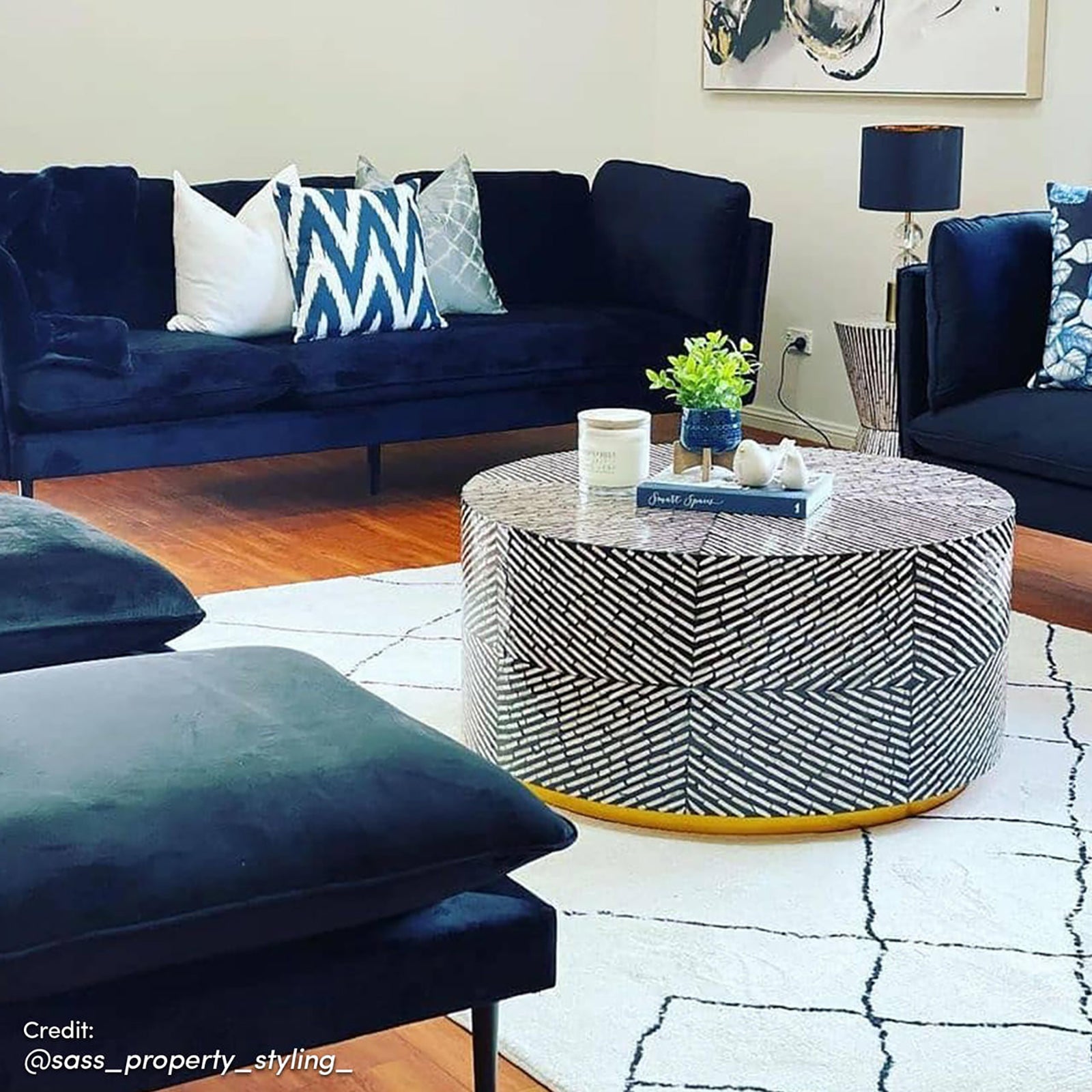 Melody Black and White Modern Floor Rug 200 x 300cm with abstract black lines on ivory, complements navy-velvet seating and a geometric-patterned coffee table, enhancing the stylish living room ambiance.