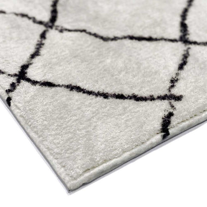 Melody Black and White Modern Floor Rug 200 x 300cm, showcasing a close-up of its cream surface with a black grid pattern, revealing pile texture and edge stitching.