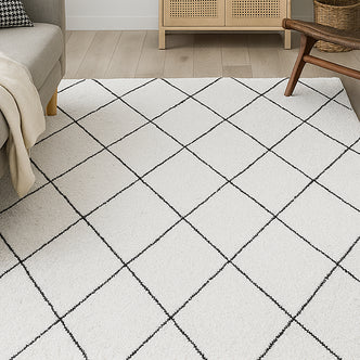 Milani 160x230cm Contemporary Printed Indoor Floor Rug with a light-cream base and black grid pattern dominates the living room scene, complemented by a nearby beige sofa and wooden furniture.