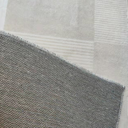 Close-up of Nicho 160x230cm Polyester Tufted Modern Abstract Indoor Rug, showcasing its tightly woven texture over a subtly checkered carpet, highlighting the rug's intricate modern design.