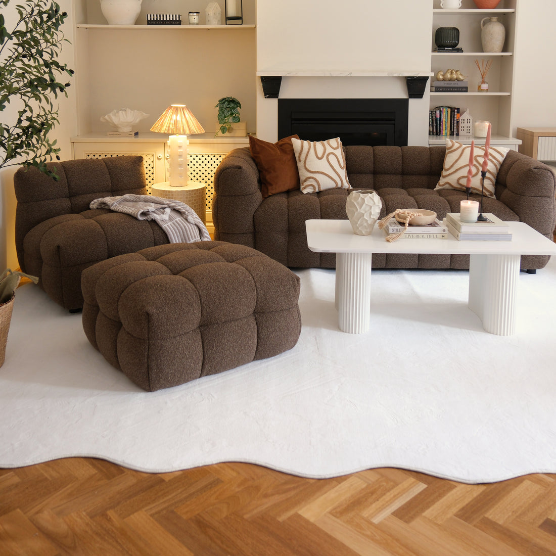 Pixie 240x330cm Large Wavy Soft Rug in Cream White graces a modern living room, enhancing the space with its plush texture and elegant pattern, complementing the chocolate-brown sofa and white decor elements.