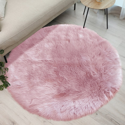 Cozy corner with a Shaddi 120cm Round Shaggy Soft Fluffy Fur Rug in Pink on light wood floor, bordered by beige sofa and wooden side table, complemented by green plant foliage.