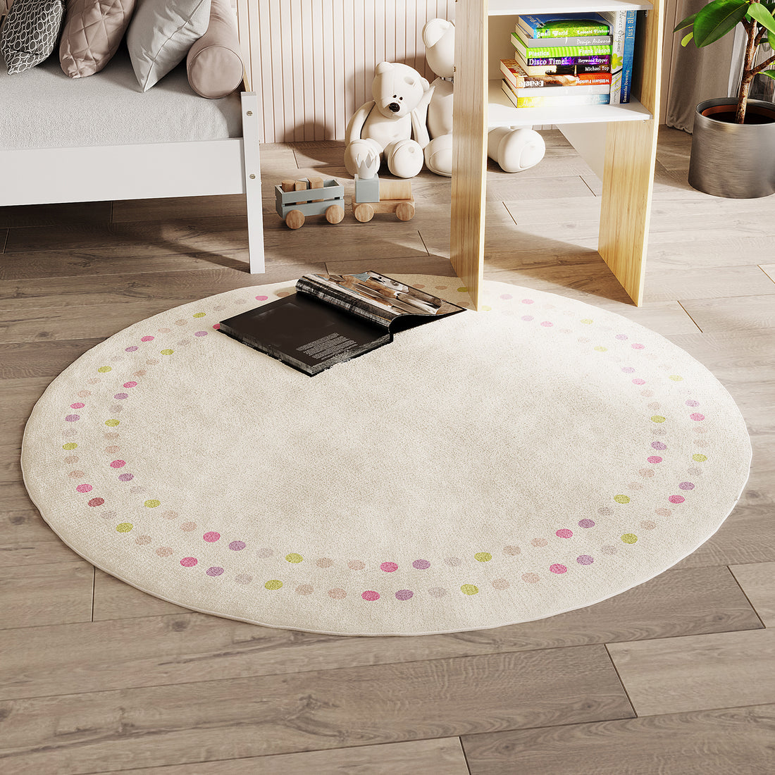 Shirin 160 Round Polka Dot Kids Indoor Rug on light wood flooring, cream with pastel dots, an open book centered. Nearby, white bed frame, wooden toy train, white teddy bears, and children's books.