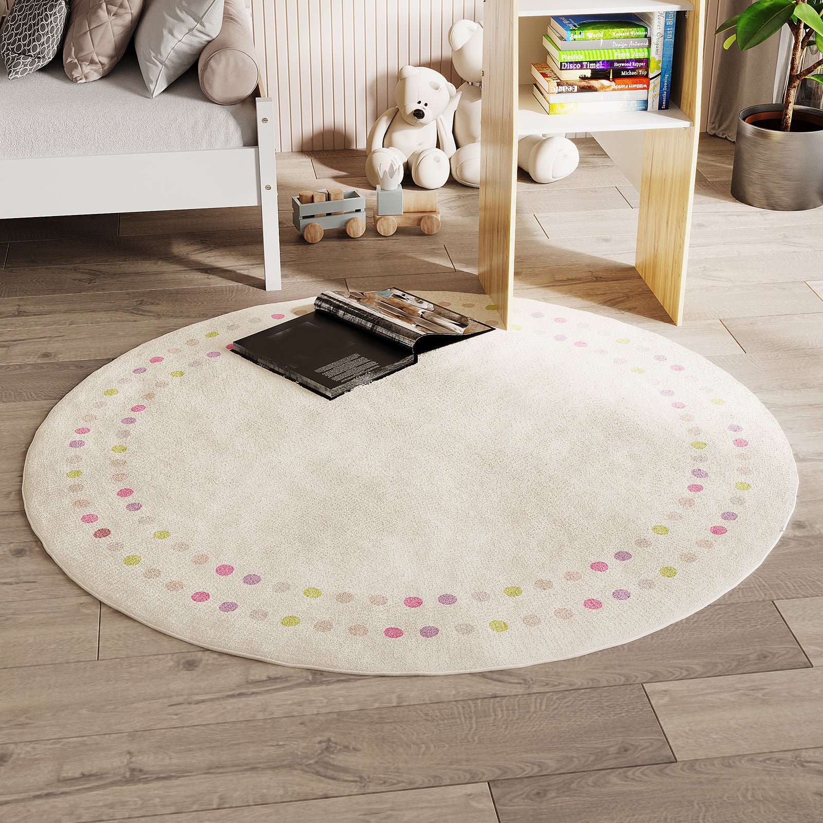 Shirin 160 Round Polka Dot Kids Indoor Rug on light wood flooring, cream with pastel dots, an open book centered. Nearby, white bed frame, wooden toy train, white teddy bears, and children's books.