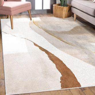 Talbyn 160x230cm Medium Contemporary Abstract Floor Rug with a neutral abstract design in creams and beiges, accented by rust-brown and muted gold, nestled between a blush chair and gray sofa.