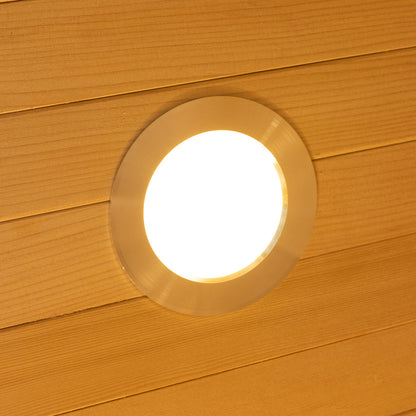 Harlow 1 Person Canadian Hemlock Infrared Home Sauna, featuring a round, recessed ceiling light in a wood-paneled ceiling, emitting a warm, diffuse glow for a cozy, indoor sauna experience.