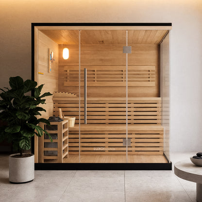 Kivi 4 Person Traditional Stove Finnish Indoor Home Sauna with glass front, wooden benches, a metal-framed heater with stones, a bucket, ladle, and a thermometer inside a minimalist spa-style setting.