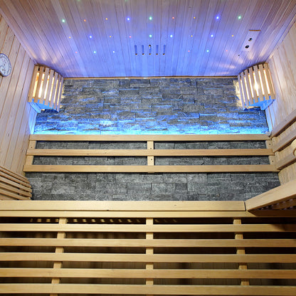 Loyly 3-Person Traditional Finnish Indoor Home Sauna with slatted wood benches, tongue-and-groove paneling, and a stacked-stone accent wall. Wooden-caged lights and star-field LED ceiling enhance the ambiance.