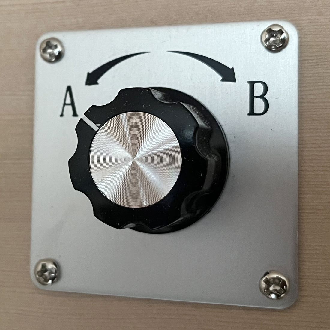 Close-up of a rotary selector switch, part of the Lue 3 Person Full Spectrum Curved Infrared Indoor Home Sauna, highlighting the simple two-position knob for easy control of sauna functions.