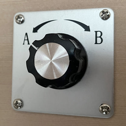 Close-up of a rotary selector switch, part of the Lue 3 Person Full Spectrum Curved Infrared Indoor Home Sauna, highlighting the simple two-position knob for easy control of sauna functions.