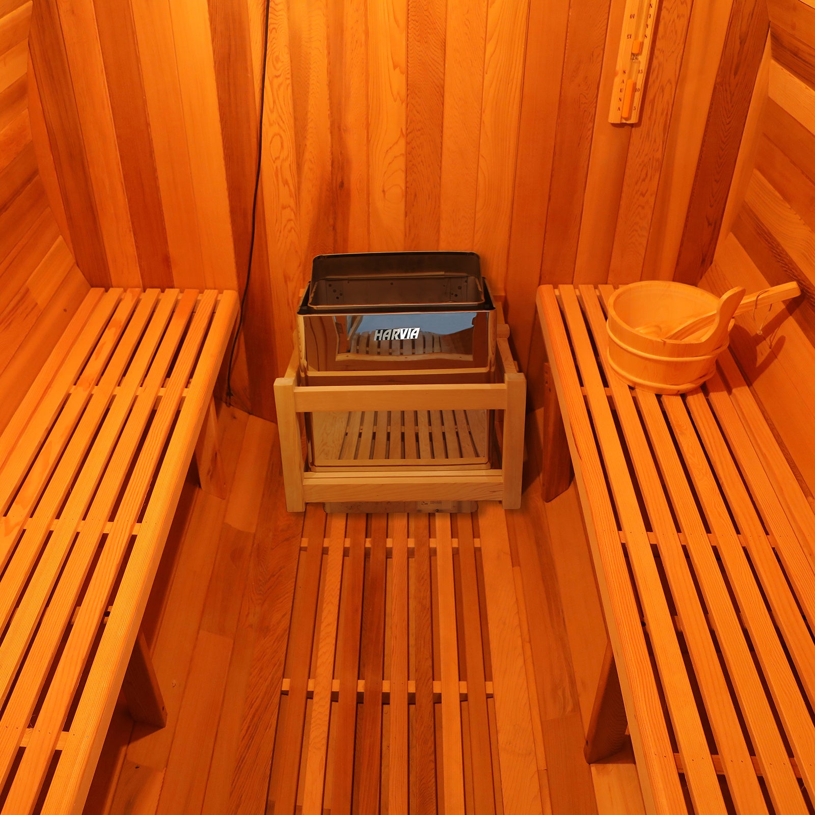 Luola 2-Person Red Cedar Barrel Sauna with Harvia Heater, featuring a wooden bench and slats, showcasing its robust construction and fine craftsmanship for an intimate outdoor wellness experience.