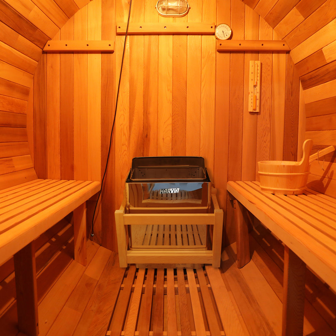 Close-up of the Luola 2-Person Red Cedar Barrel Sauna with Harvia Heater, highlighting its wooden texture and barrel design, showcasing luxury and wellness for outdoor relaxation.