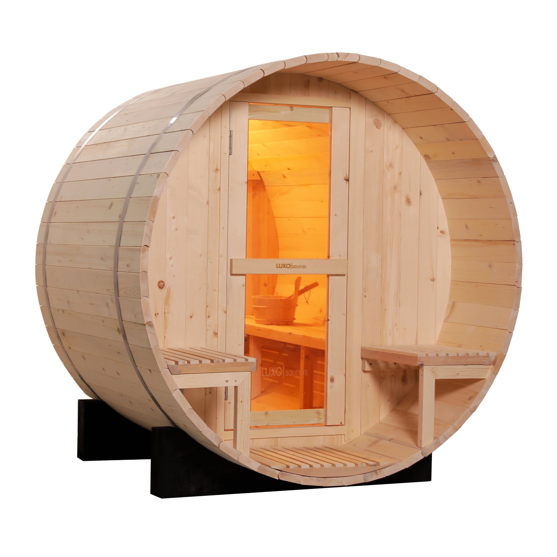 Luola 2 Person Pine Outdoor Barrel Sauna & Harvia Stove features a wooden barrel design with a glass-paneled door, slatted benches, and warmly lit interior, highlighting its inviting and relaxing sauna setup.