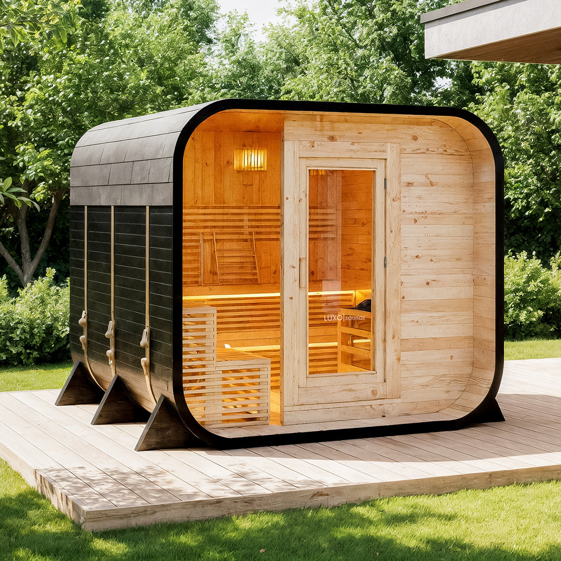 Medika 8 Person Traditional Finnish Outdoor Home Sauna on a wooden deck by a lakeshore, featuring a dark wood exterior, light wood interior, bench seating, and three secure exterior straps.