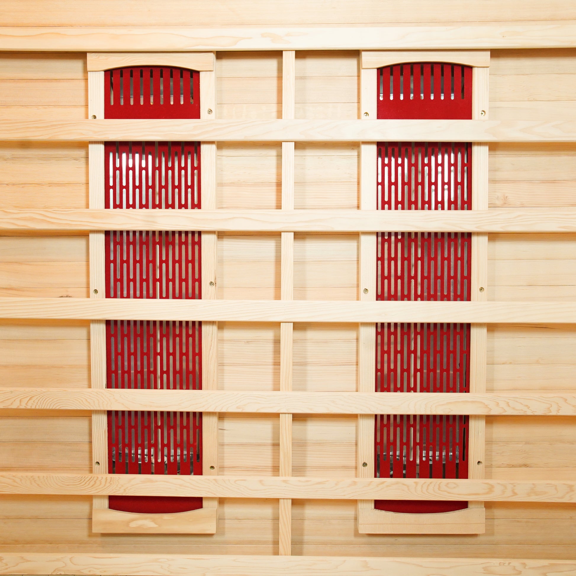 Taavi 2 Person Ceramic Infrared Indoor Home Sauna with vertical red infrared-heating panels on light wood backing, enclosed by a horizontal slat framework, and resting on a matching wood floor.