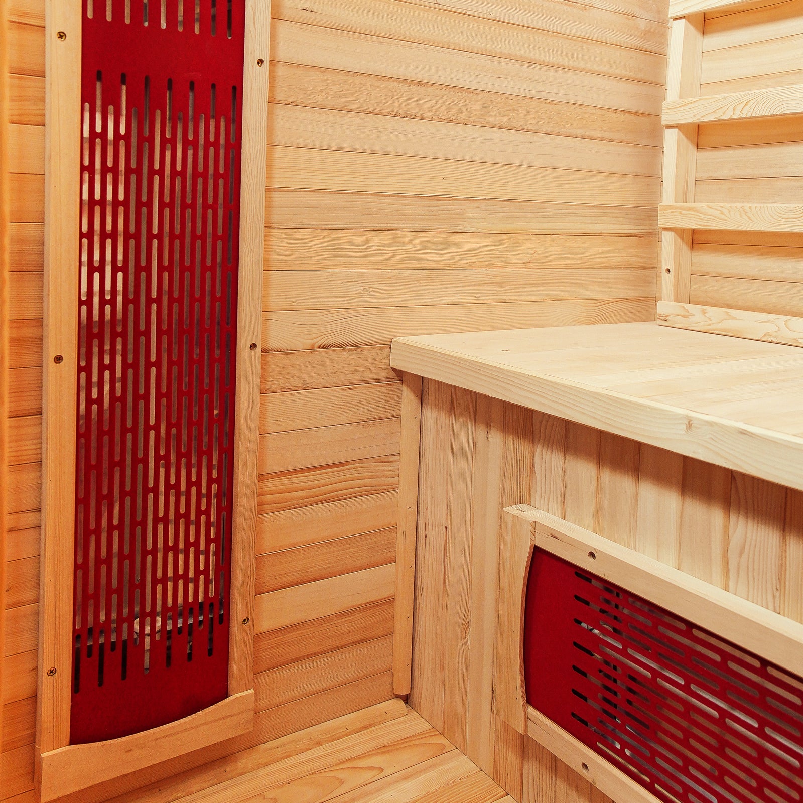Taavi 2 Person Ceramic Infrared Indoor Home Sauna with tongue-and-groove wood paneling, built-in bench, and vertical red-backed infrared heater panels, offering a compact, spa-like relaxation space.