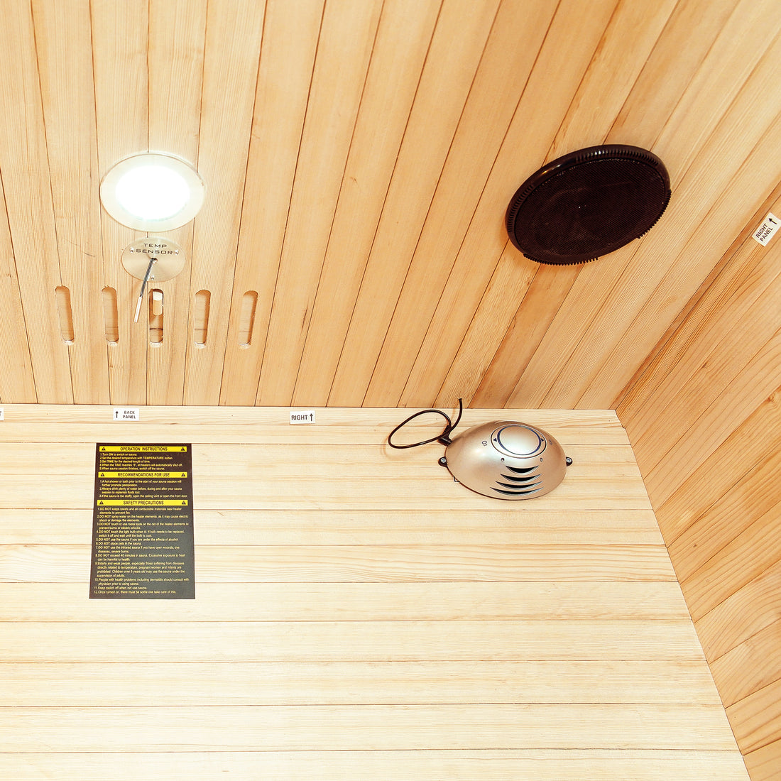 Taavi 2 Person Ceramic Infrared Indoor Home Sauna featuring tongue-and-groove wood paneling, TEMP SENSOR, recessed light, speaker grille, control module, and safety label, ideal for home relaxation and therapy.