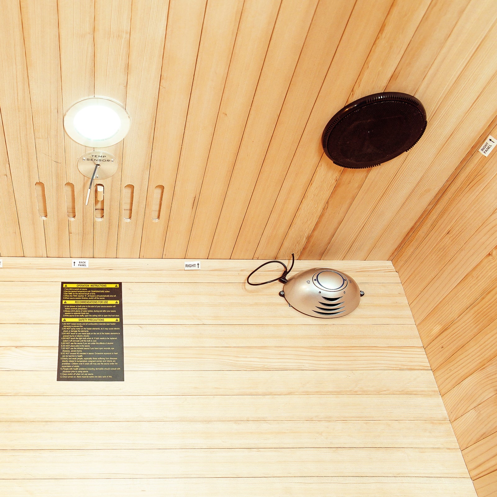 Taavi 2 Person Ceramic Infrared Indoor Home Sauna featuring tongue-and-groove wood paneling, TEMP SENSOR, recessed light, speaker grille, control module, and safety label, ideal for home relaxation and therapy.