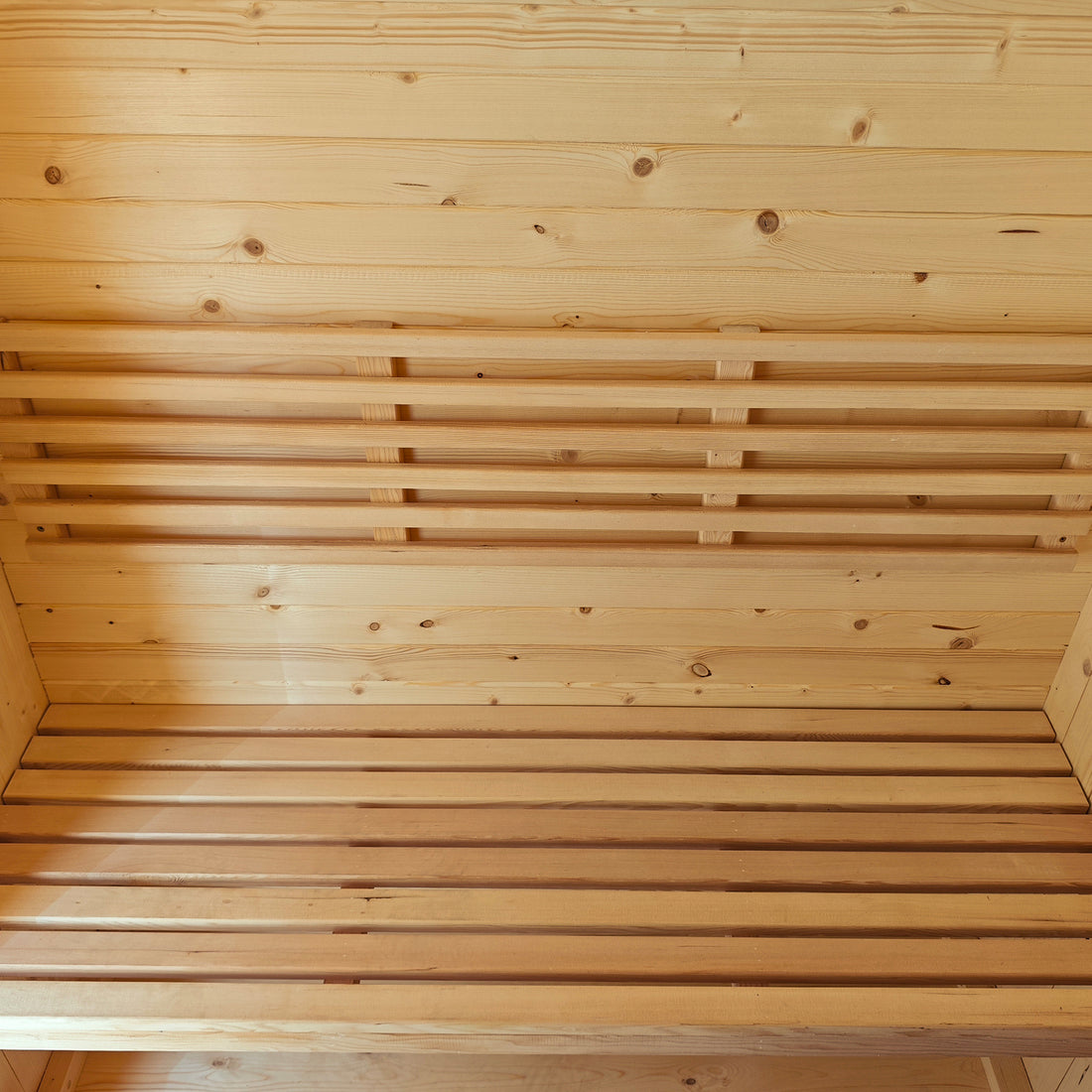 Tarni 2-Person Finnish Outdoor Sauna – Fir Wood interior with light wooden paneling and two-tier benches, showcasing a spacious, serene setting for at-home relaxation and wellness.