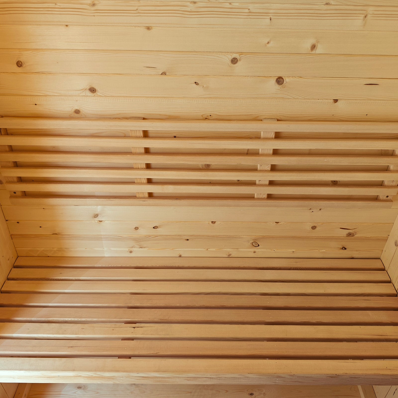 Tarni 2-Person Finnish Outdoor Sauna – Fir Wood interior with light wooden paneling and two-tier benches, showcasing a spacious, serene setting for at-home relaxation and wellness.
