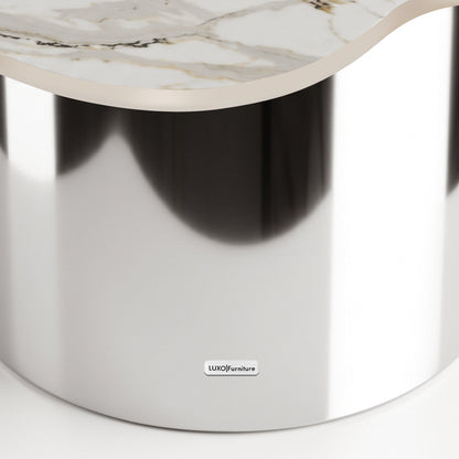 Close-up of a luxury table with a reflective metallic base and marble-like top on a white background
