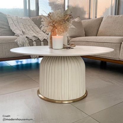 Combee 80cm Sintered Stone Coffee Table Cream White displayed indoors, showcasing its smooth stone top and unique design, accompanied by furniture elements like a couch and vase, highlighting its versatile placement.