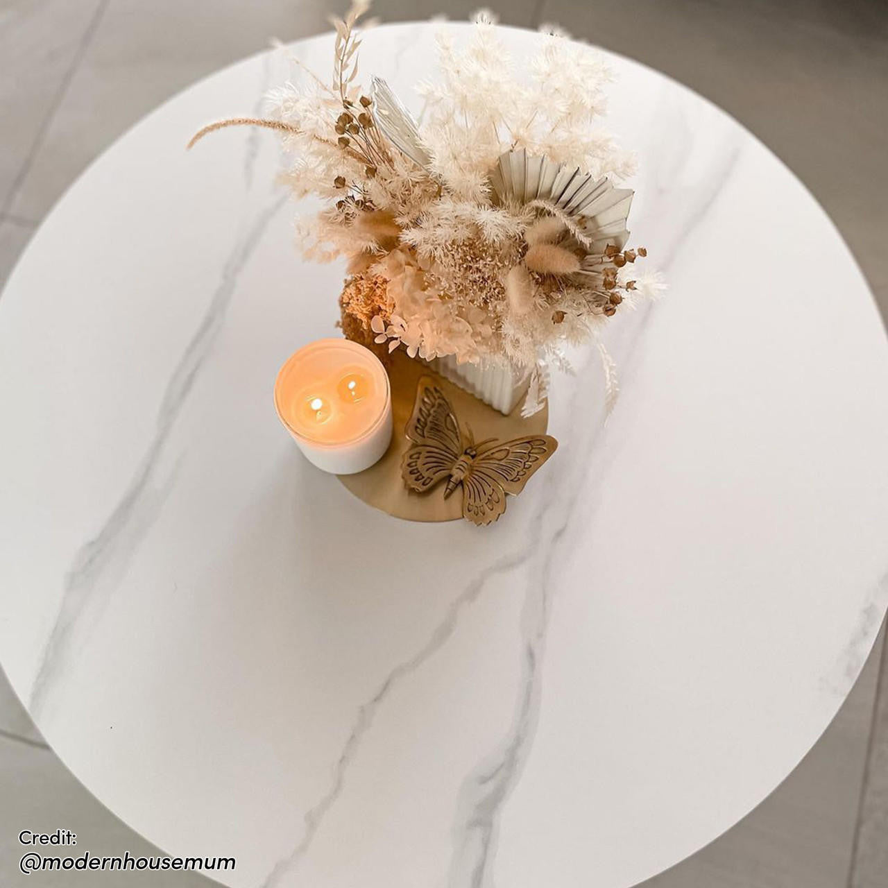 Combee 80cm Sintered Stone Coffee Table Cream White with a smooth top and microfiber leather base, set with a candle and vase, enhancing its appeal as an accent piece.