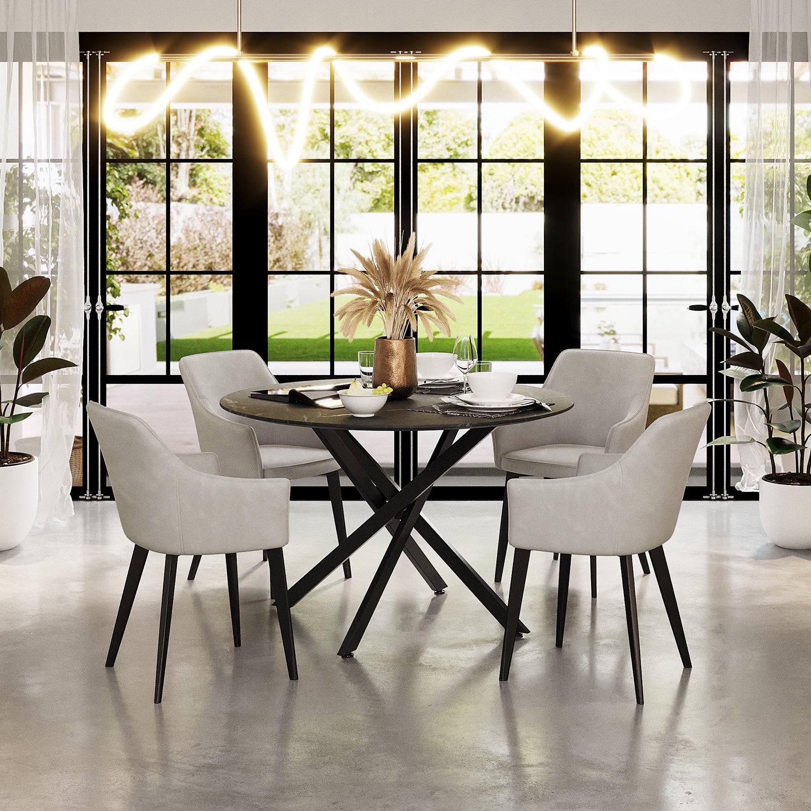Ella Velvet Dining Chair Set of 2 in Beige around a dark-toned dining table, featuring plush beige velvet upholstery, black metal legs, and elegant design in a sunlit, contemporary dining nook.