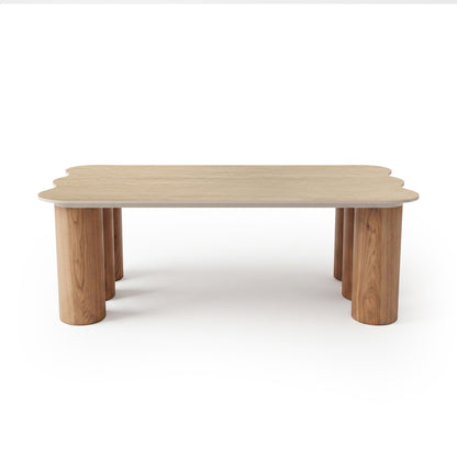 Light wood table with scalloped edges and cylindrical legs on white background