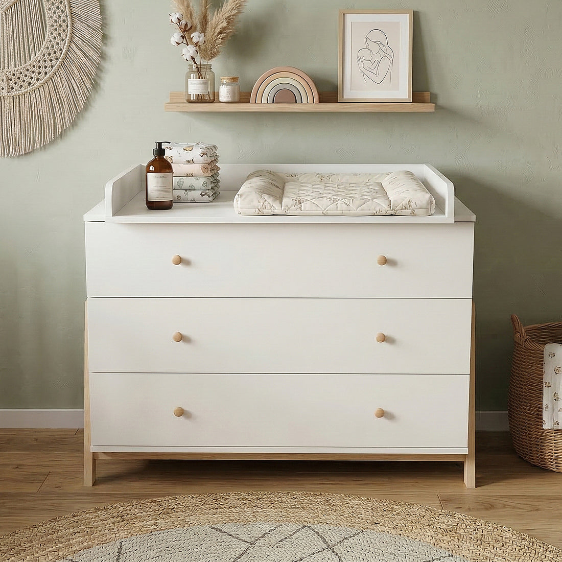 White dresser used as a changing table in a styled nursery with decor and changing pad