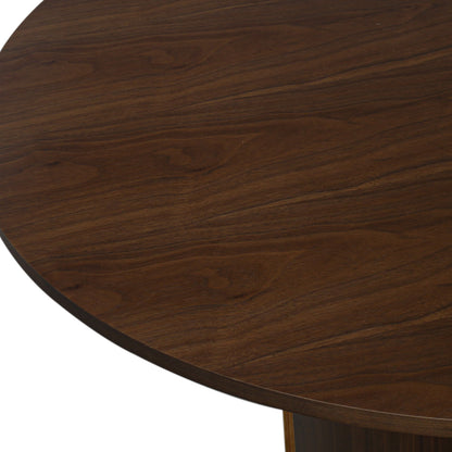 Close-up of the Kaylani & Winfield 5-Piece Wooden Dining Set, showcasing the round veneer table's smooth walnut finish and the sleek design of the black velvet upholstered chairs.