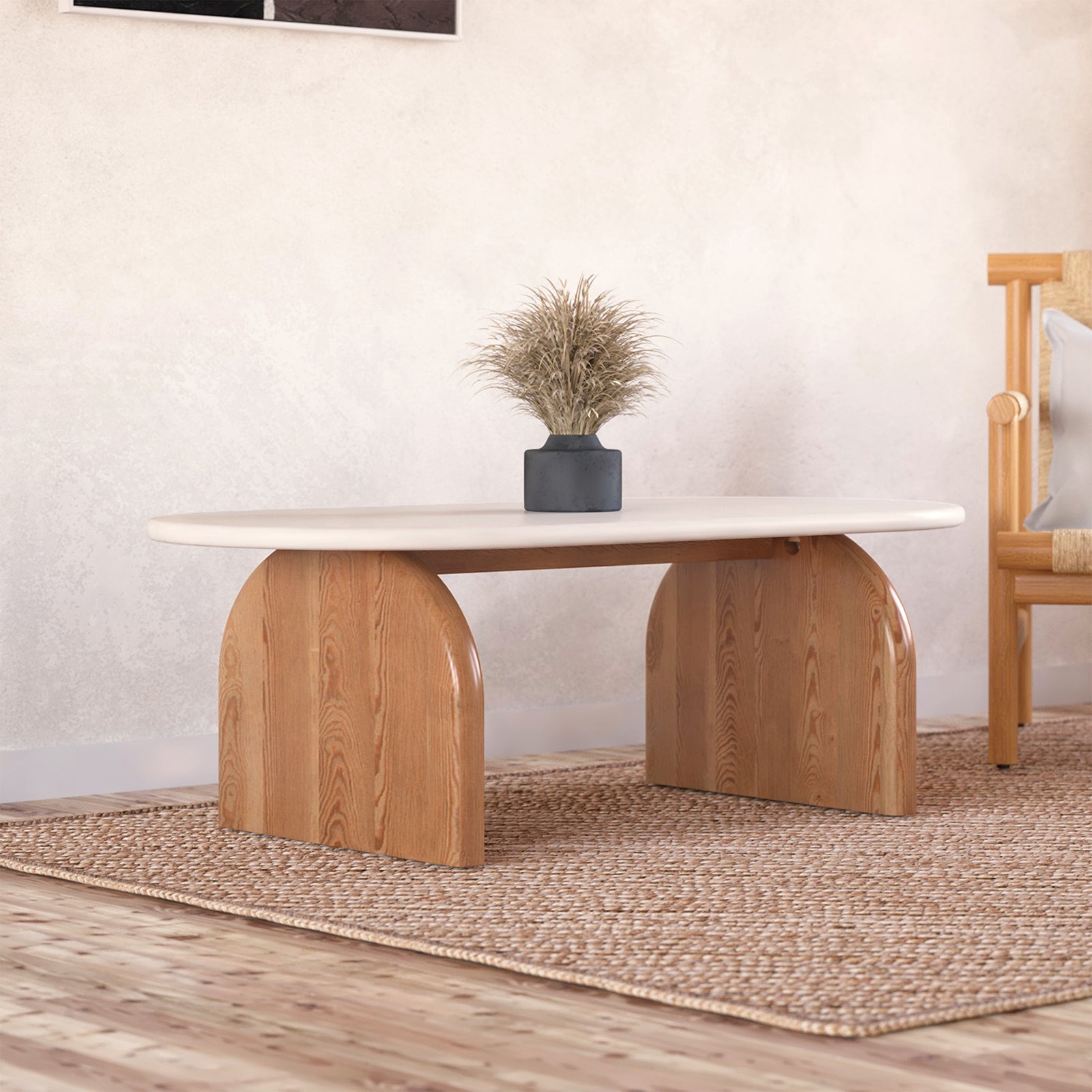 Kerry 120cm Solid Oak Oval Coffee Table - White Natural features a sleek oval design with a white tabletop, supported by sturdy natural oak legs, complemented by a houseplant and rug for a chic living room setup.