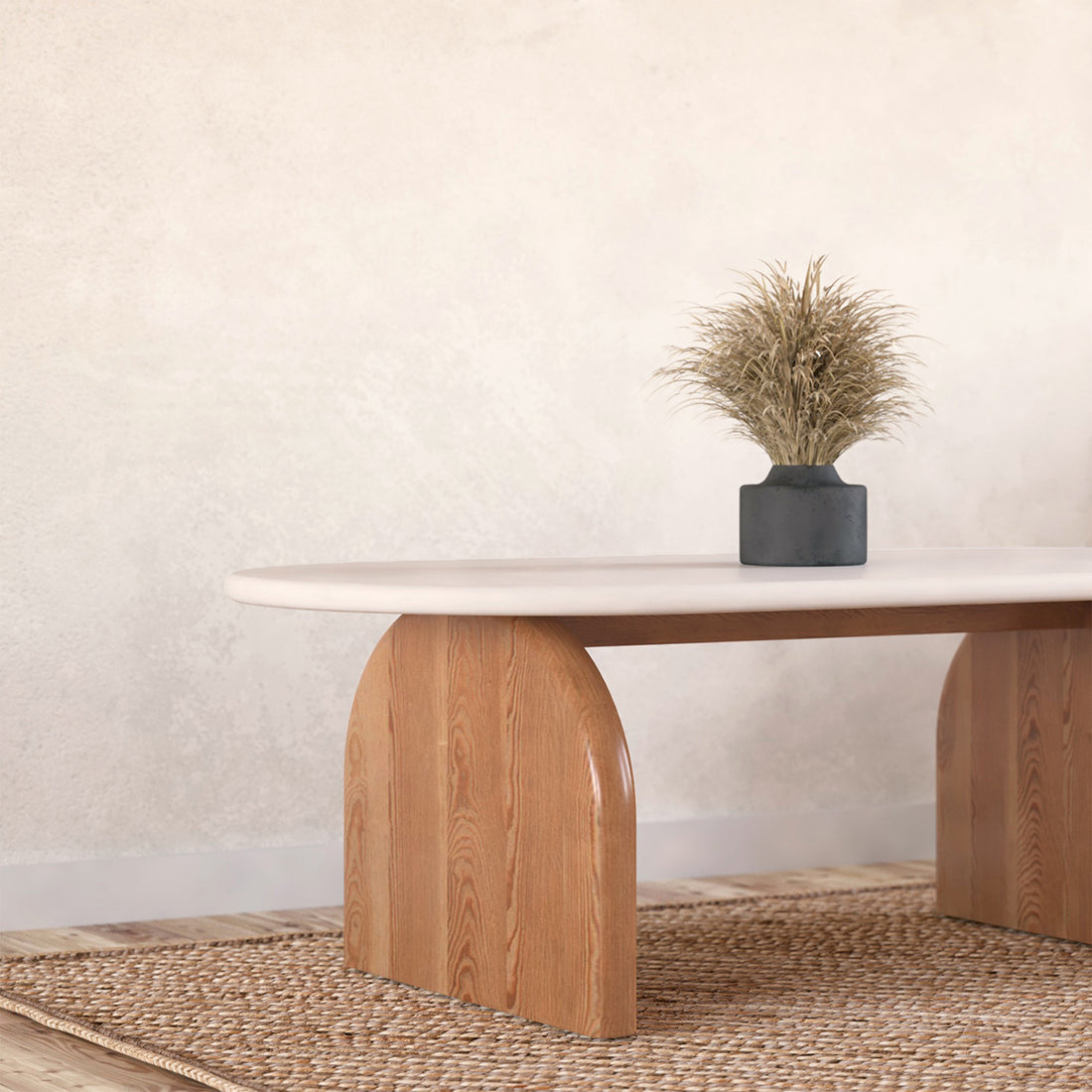 Close-up of the Kerry 120cm Solid Oak Oval Coffee Table - White Natural, showcasing its smooth white tabletop and sturdy natural oak legs, adorned with a small houseplant and vase on a wooden surface.