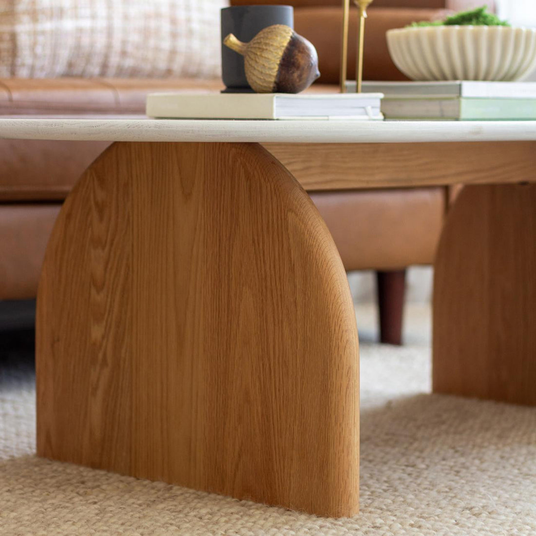Close-up of the Kerry 120cm Solid Oak Oval Coffee Table featuring a white tabletop and sturdy natural oak legs, highlighting its modern design and durable construction for a stylish living room centerpiece.