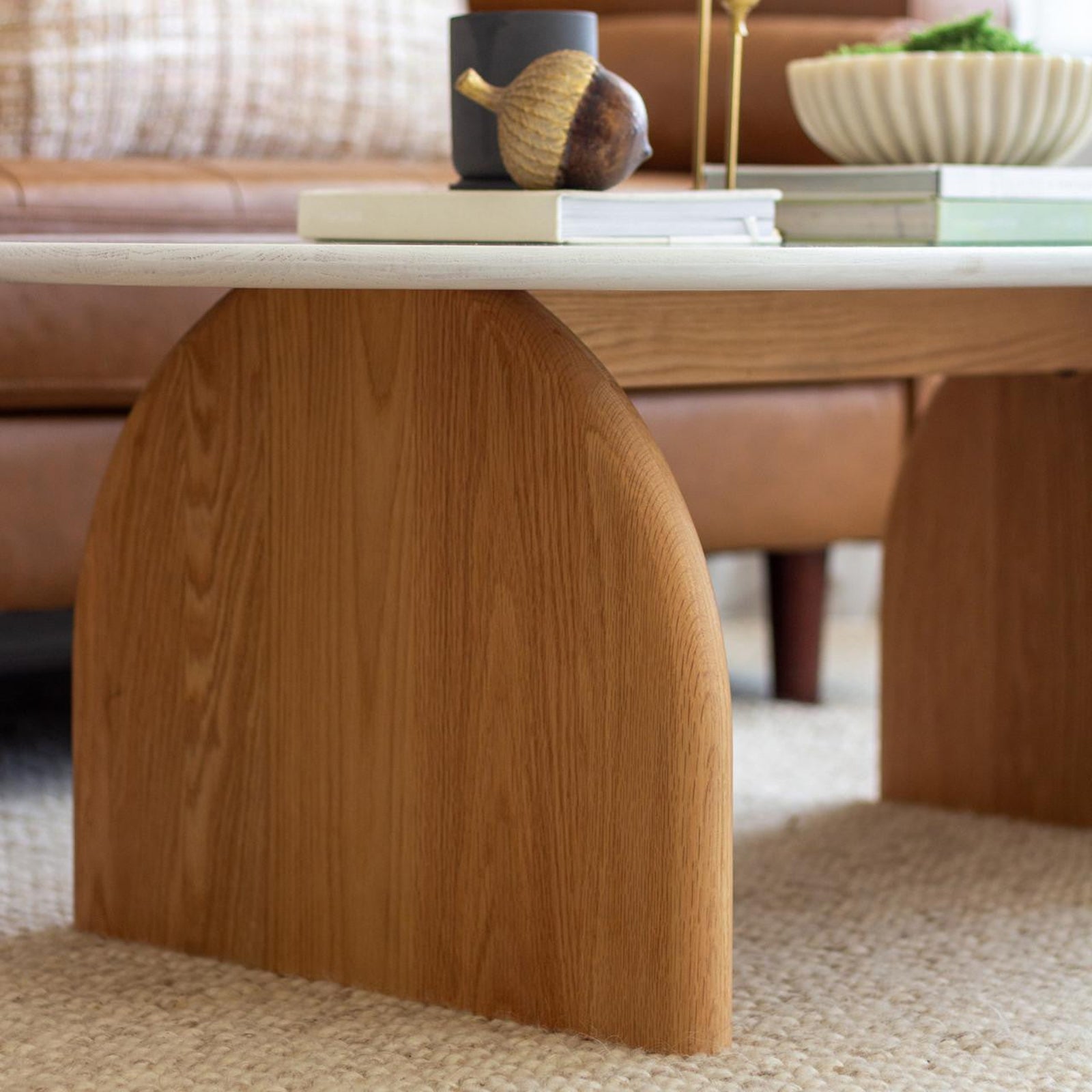 Close-up of the Kerry 120cm Solid Oak Oval Coffee Table featuring a white tabletop and sturdy natural oak legs, highlighting its modern design and durable construction for a stylish living room centerpiece.